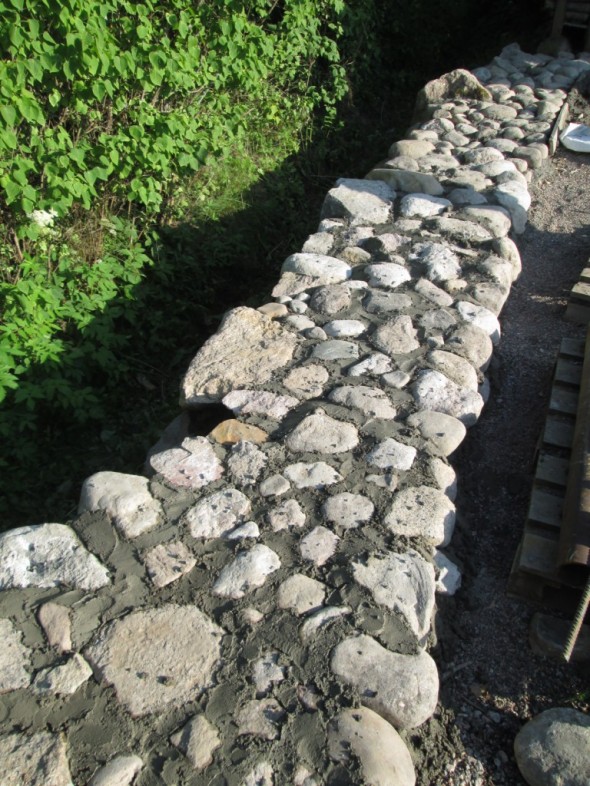Betonia jäi jonkin verran yli, ja ylimääräisellä betonilla laitettiin pyöreitä kiviä tontin laidalla olevan avo-ojan viereen.