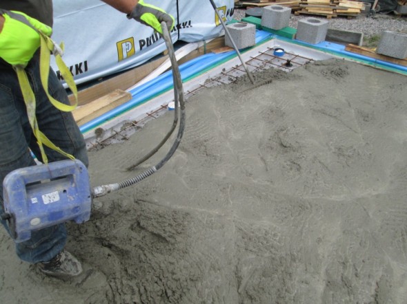 Itsetasoittuvan HT-betonin levittämistä vibralla ja haravalla. Ja levisihän se, kun on riittävän järeät työkalut.