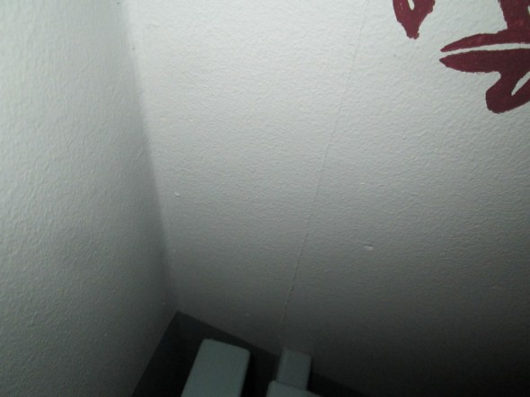 Vuokra-asunnon portaikko. Kipsilevyn sauma ja naulan kannat ovat tulleet näkyville.