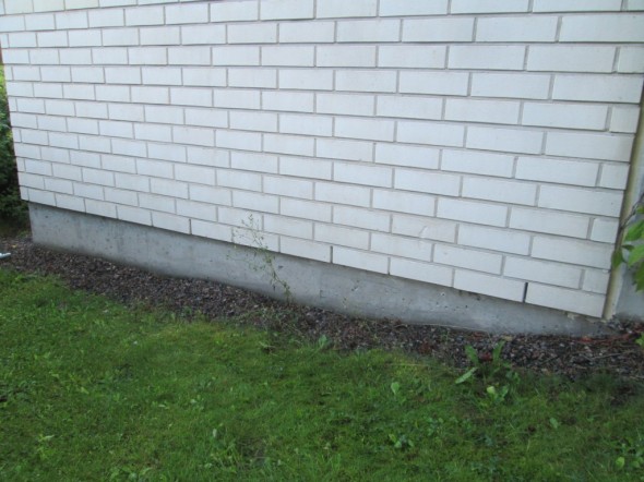 Talon päädyssä seinän tiiliverhoilussa on alimman tiilirivin joka kolmas tiili jätetty oikeaoppisesti kokonaan ilman laastia. Nyt sitten seuraavaksi tehdään reikiä tähän tiiliseinän alla olevaan betonipintaan alapohjan alapuolelle, ja imetään radonit sitä kautta pois.