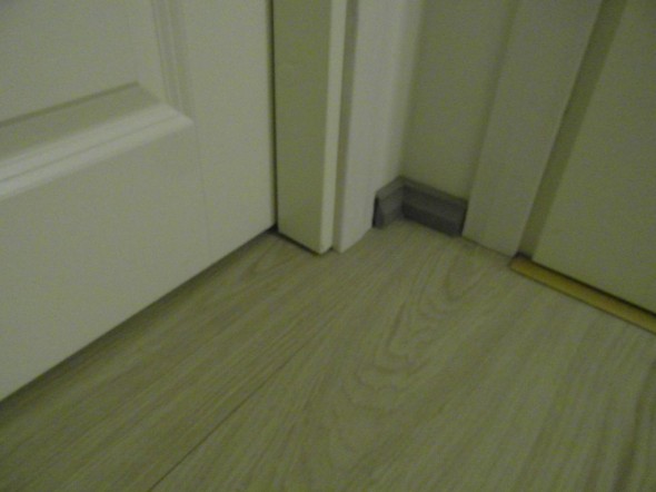 Makuuhuoneen ovi ja WC:n ovi yläaulasta katsottuna. Makuuhuoneeseen päin menee yhtenäinen lattia ilman kynnystä, ja tuuletusrako toimii oven alla.