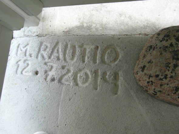 Tasan vuosi sitten oli päärappusten kulmassa betoni vielä märkää. Signeeraus tehty 8 mm harjaterästä kynänä käyttäen. "M.Rautio" -nimisiä henkilöitä asuu tällä hetkellä Talo-Rautiossa 4 kpl, koska meidän kaikkien etunimet alkaa M-kirjaimella.